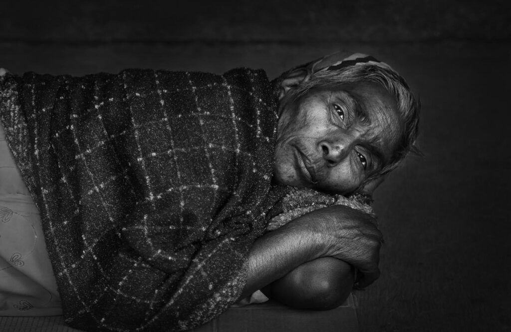 Rest on the street Indian woman resting in urban environment, India - stock photo
