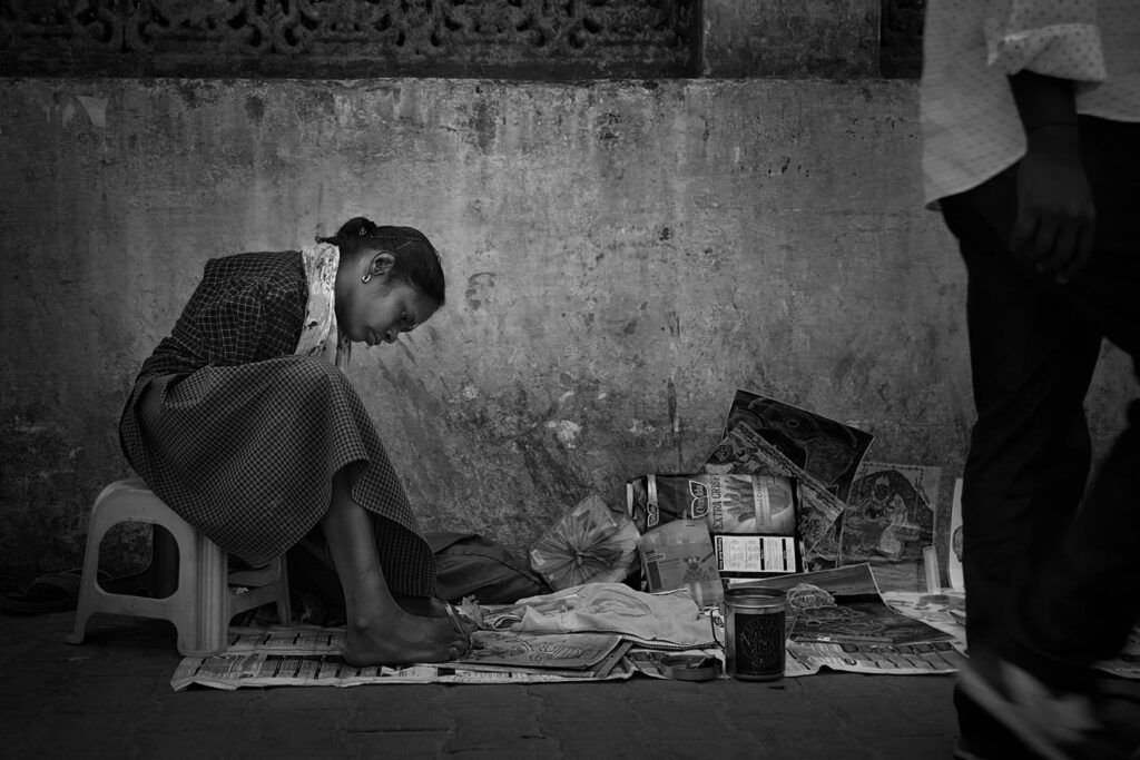 Indian girl Indian girl sitting in the street and painting with her feet - stock photo