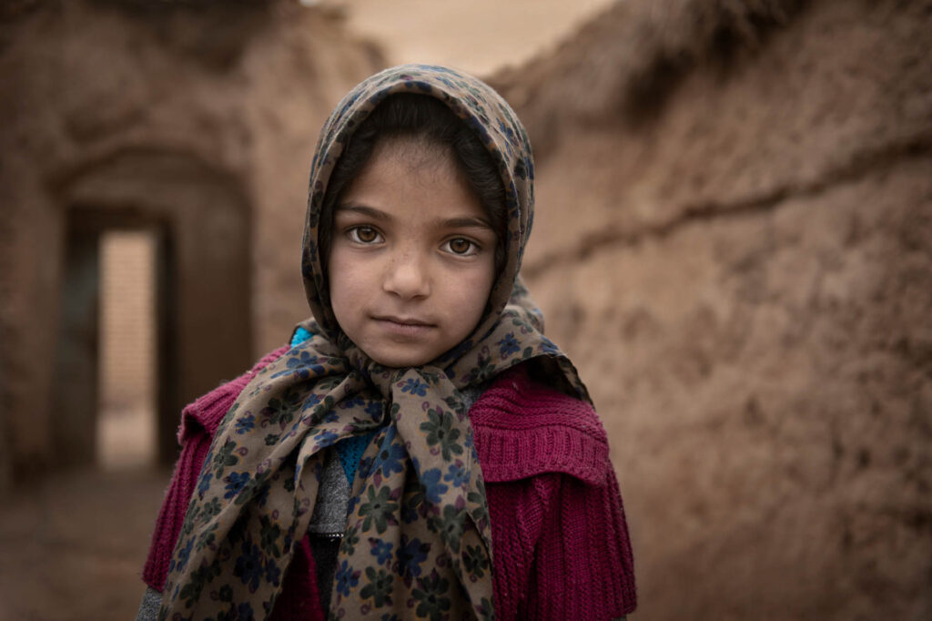 Mahtaj Portrait of Iranian little girl standing in the village house - stock photo
